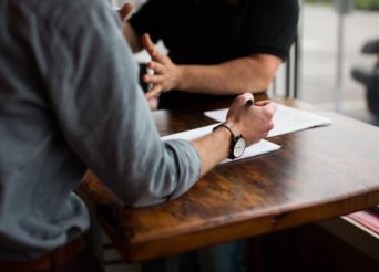 Deux hommes autour d'une table discutant sérieusement