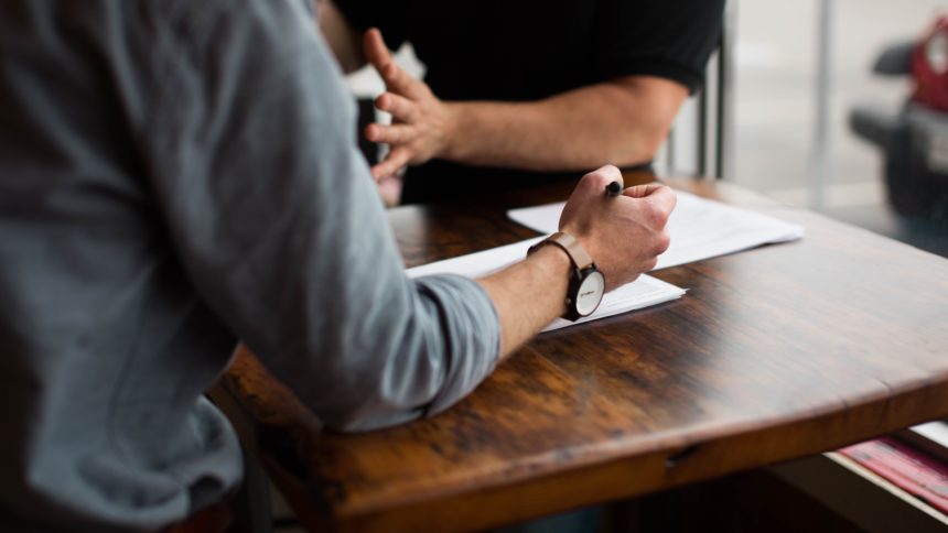 Deux hommes autour d'une table discutant sérieusement